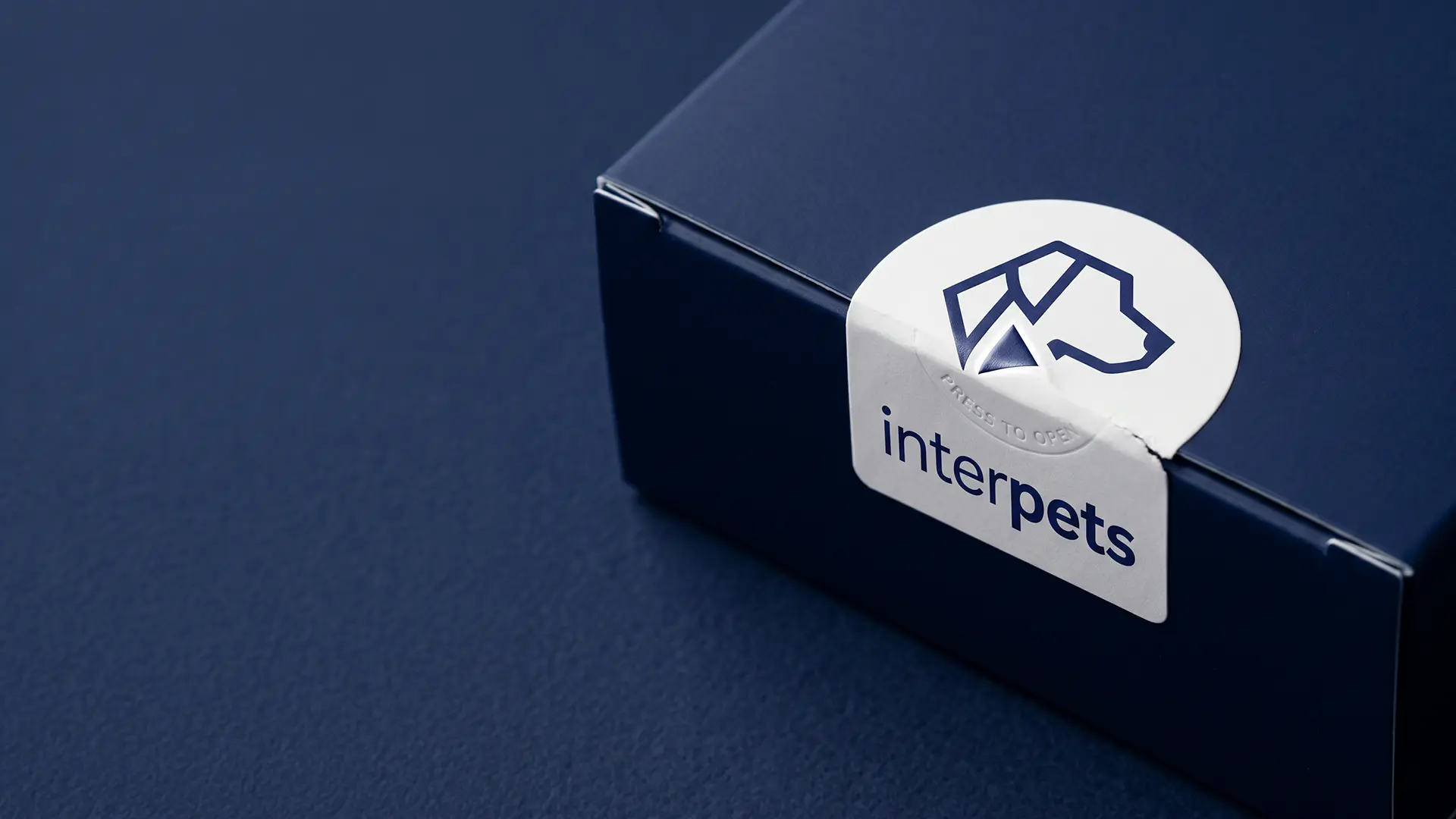 Logo Interpets na naklejce zamykającej granatowe pudełko, realizacja Skubi Art