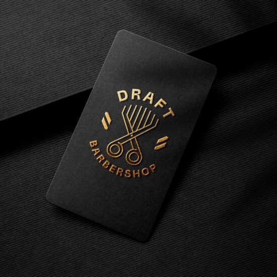 Złote logo DRAFT BarberShop z nożyczkami i grzebieniem