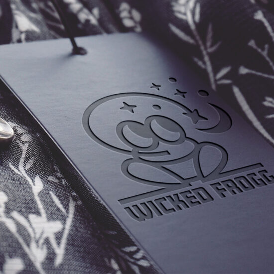 Tłoczone logo Wicked Frogg na ciemnym materiale